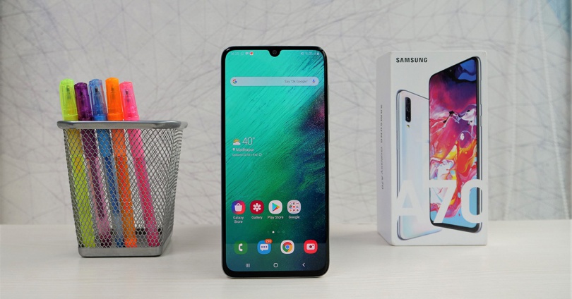 Frontal del Galaxy A70 junto a su caja y lapices de colores